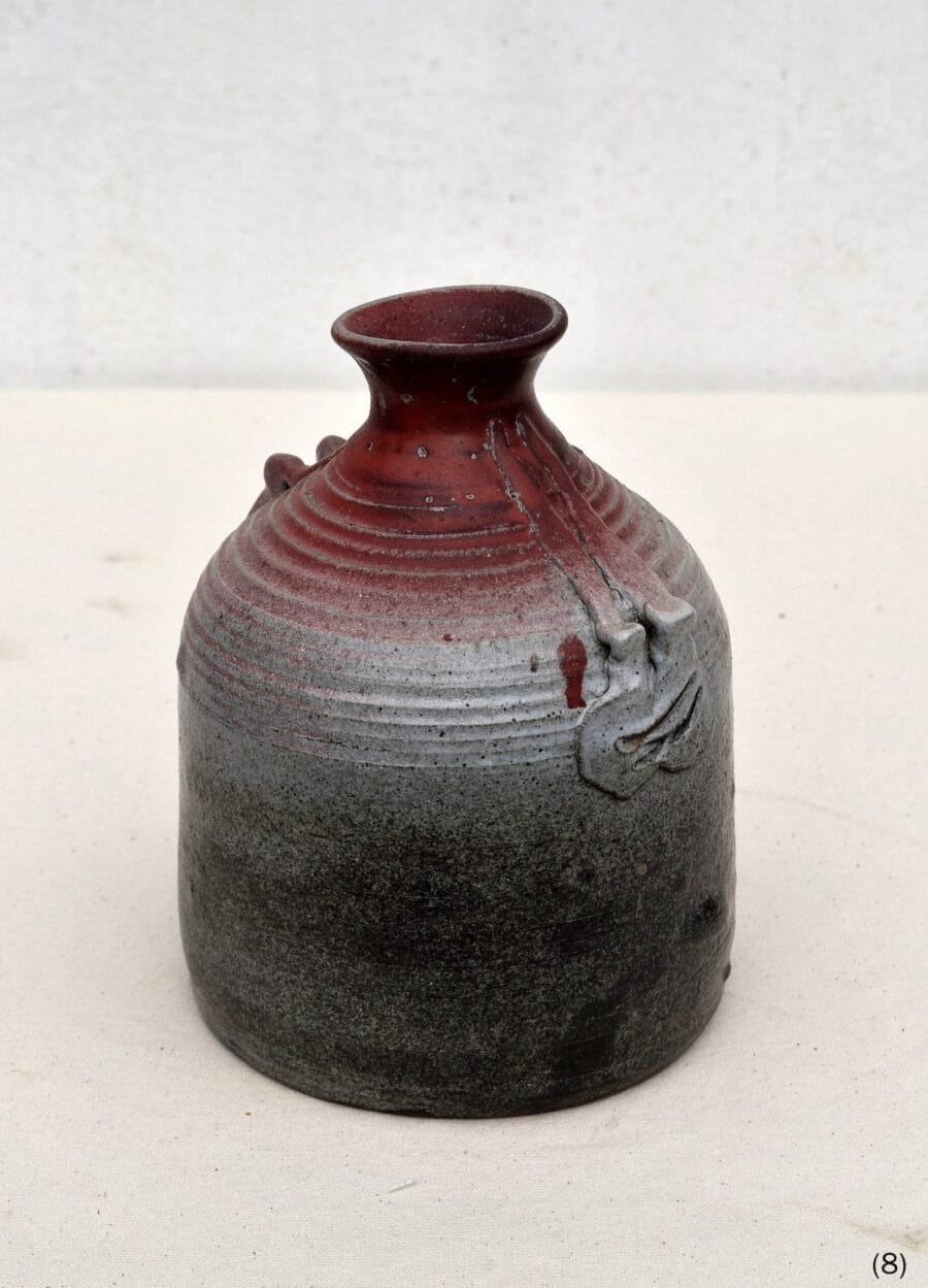 High-fired ceramic bottle with crimson to graphite gradient glaze and textured ribbing by Luis Mandiola